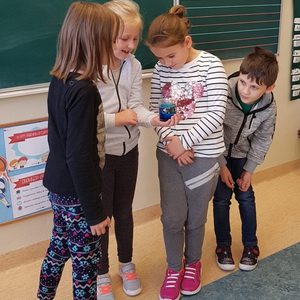 dzieci prezentują eksperyment z musującą tabletką i barwnikiem.jpg
