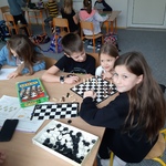 uczniowie przy stoliku grają w szachy.jpg